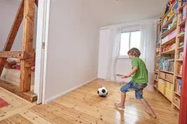 Ein Kind spielt in der Wohnung Fußball