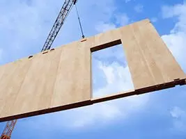Wand eines Hauses wird durch einen Kran positioniert
