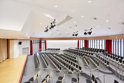 Bühne mit mehreren Reihen Stühlen für ein Publikum