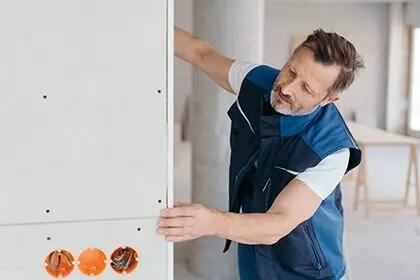 Person baut Wand zusammen