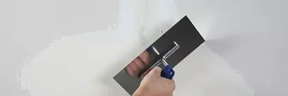 Person verspachtelt Wand