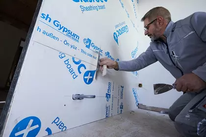 Person verspachtelt Wand